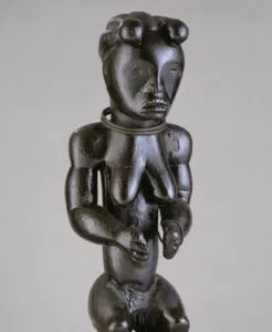 Figura femenina Fang de cuerpo entero tallada en madera, detalle lateral que muestra la musculatura y proporciones típicas del arte de Río Muni.